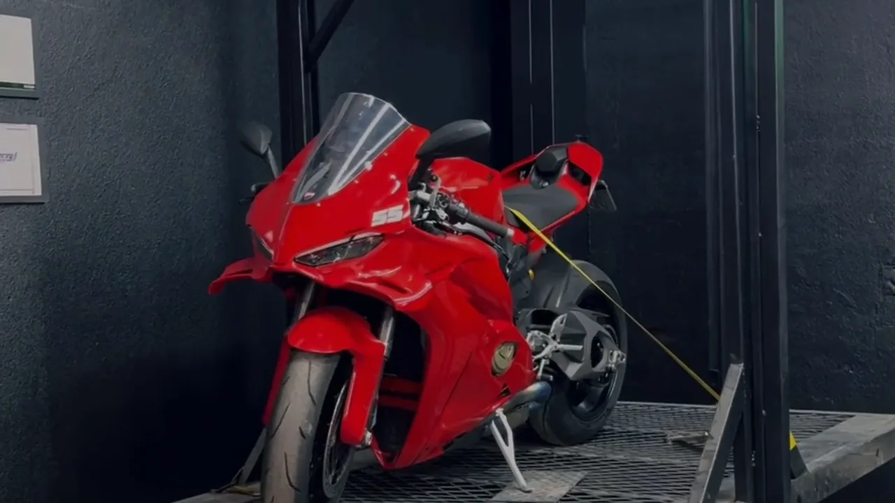Moto esportiva vermelha sobre a plataforma da oficina Edilson SBK Superbikes